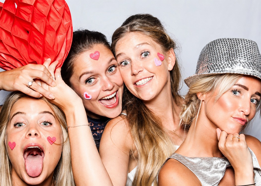 een witte achtergrond photobooth foto met poserende dames